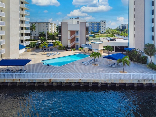 view of swimming pool featuring a patio and a water view