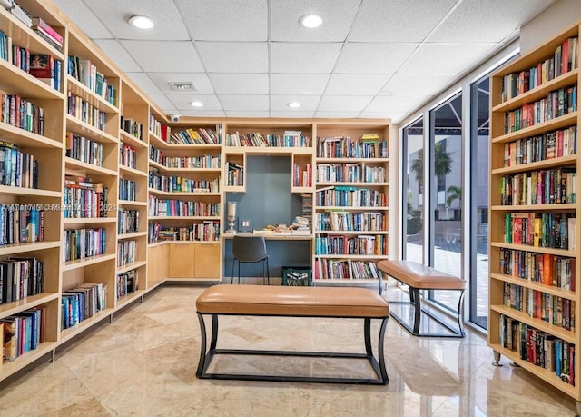 sitting room featuring a paneled ceiling and expansive windows