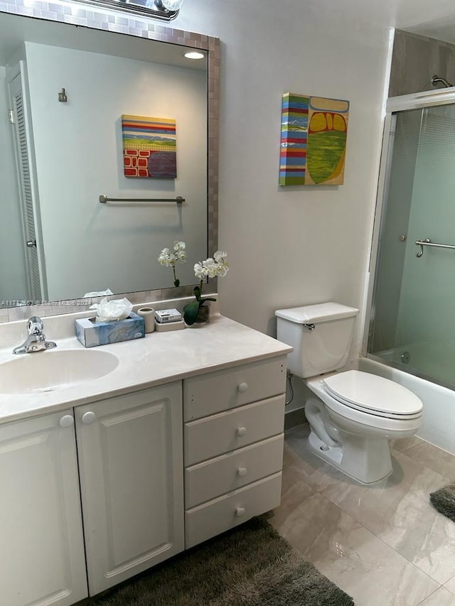 full bathroom with vanity, bath / shower combo with glass door, and toilet