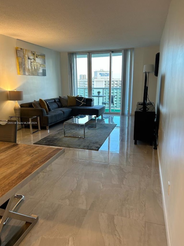 living room with a textured ceiling and a wall of windows