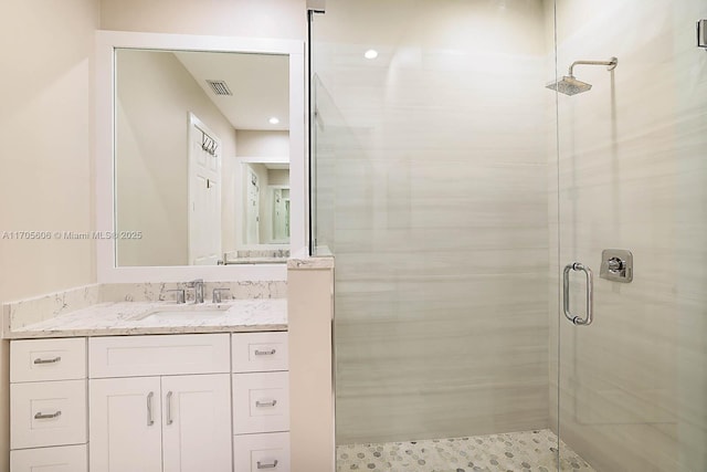 bathroom featuring vanity and a shower with shower door