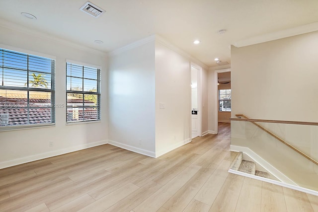 empty room featuring light wood-type flooring and crown molding