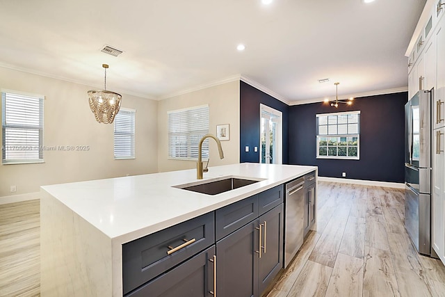 kitchen featuring sink, a chandelier, a center island with sink, and appliances with stainless steel finishes