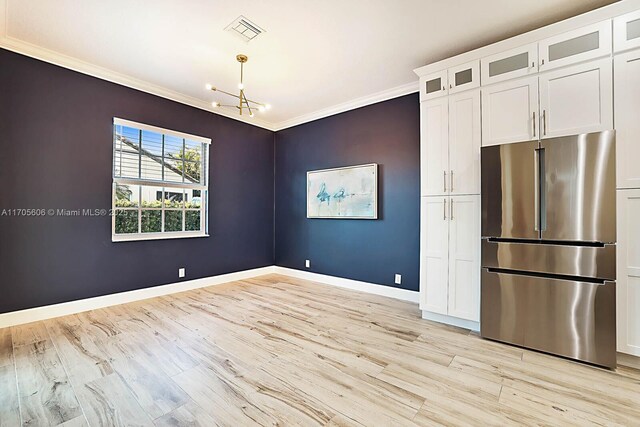 unfurnished dining area with a chandelier, light hardwood / wood-style flooring, and crown molding