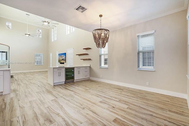 kitchen featuring a chandelier, light hardwood / wood-style flooring, wine cooler, and a wealth of natural light