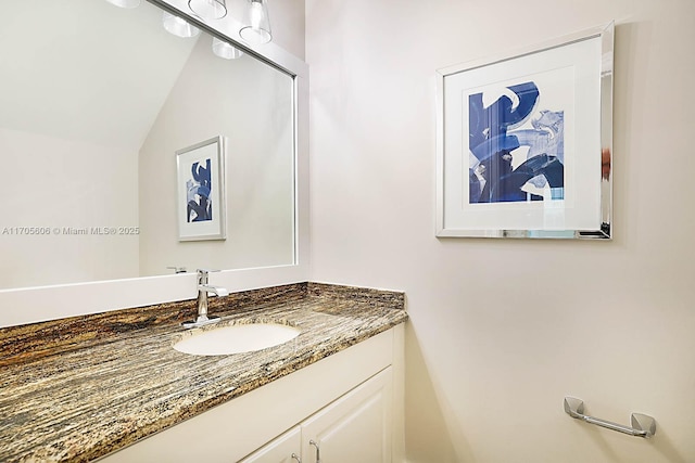 bathroom with vanity and lofted ceiling