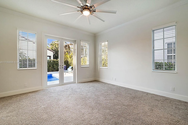 carpeted spare room featuring ceiling fan, french doors, and ornamental molding