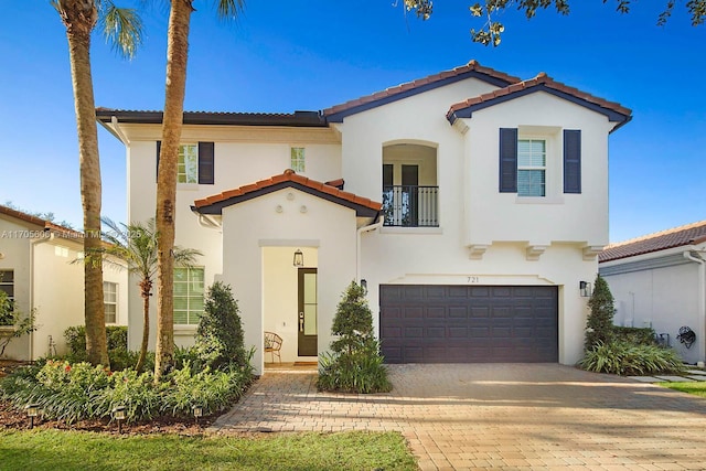 mediterranean / spanish house featuring a balcony and a garage