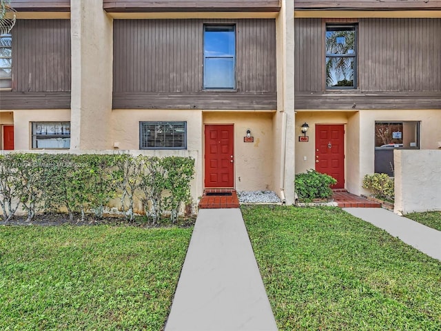 view of front of home with a front lawn and stucco siding