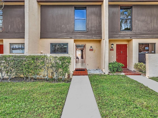 view of front of home with stucco siding and a front yard