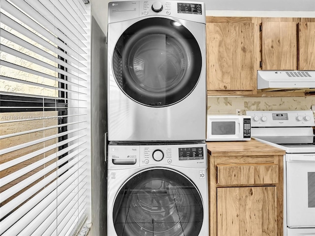 washroom featuring stacked washer and dryer and laundry area