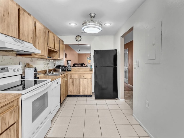 kitchen featuring white appliances, light countertops, under cabinet range hood, a sink, and light tile patterned flooring