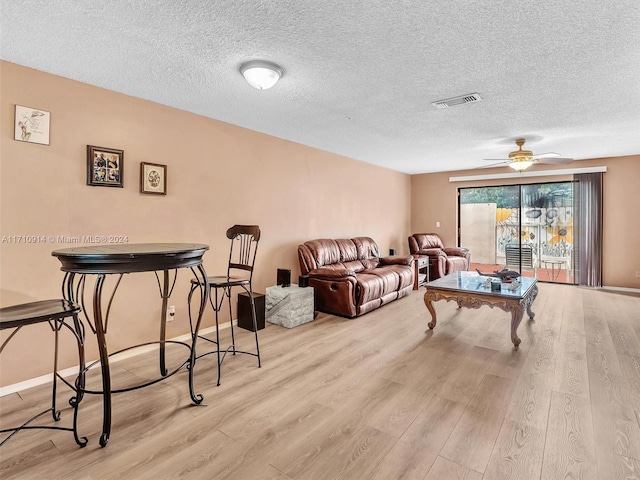 living area featuring baseboards, visible vents, and light wood-style floors