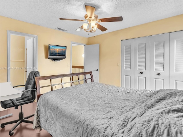 bedroom with a textured ceiling, ceiling fan, a closet, and visible vents