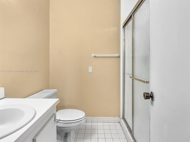 full bathroom featuring tile patterned flooring, toilet, vanity, baseboards, and an enclosed shower