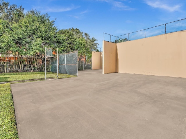 view of home's community with community basketball court and fence