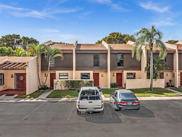 view of front facade featuring uncovered parking and stucco siding