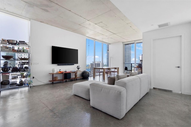 living room with concrete floors and floor to ceiling windows