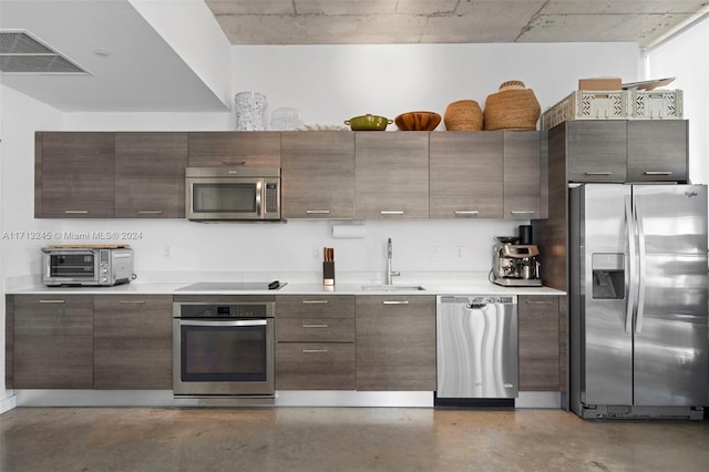 kitchen with dark brown cabinetry, sink, and appliances with stainless steel finishes