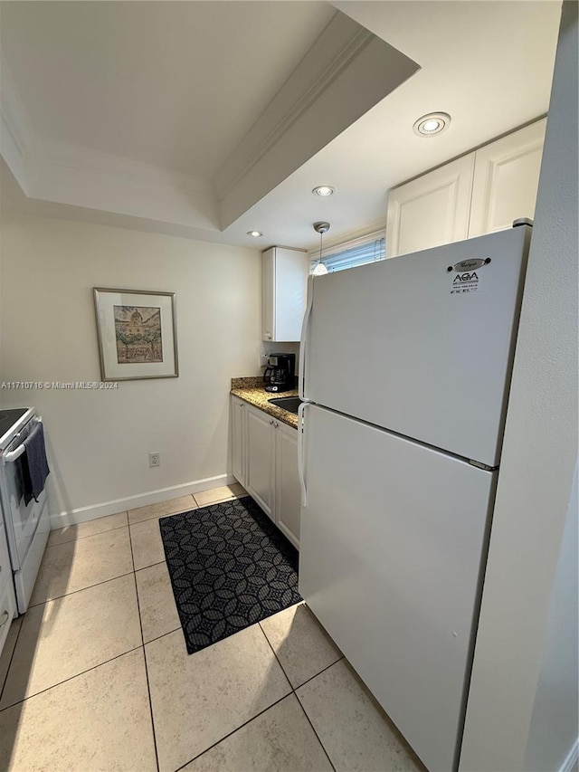 kitchen featuring a tray ceiling, white cabinetry, white fridge, and hanging light fixtures