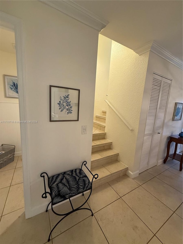 staircase featuring tile patterned flooring and crown molding