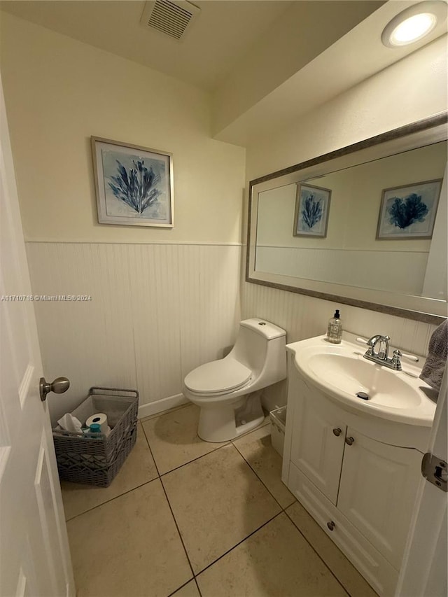 bathroom with tile patterned flooring, vanity, and toilet