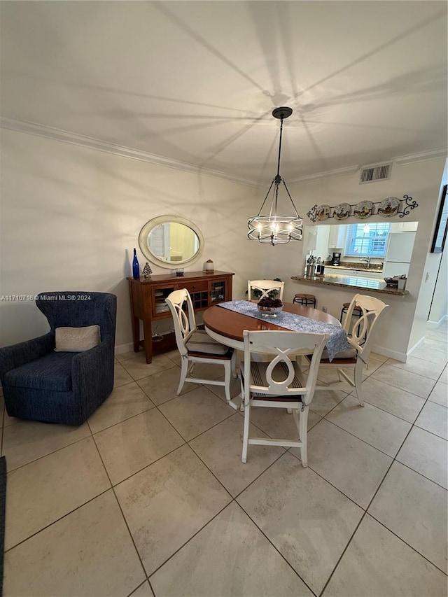 dining room with an inviting chandelier, light tile patterned floors, and ornamental molding