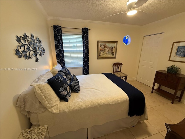 tiled bedroom with a textured ceiling, ceiling fan, and ornamental molding