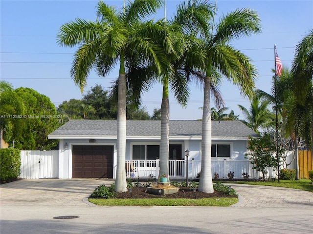 single story home featuring a porch and a garage