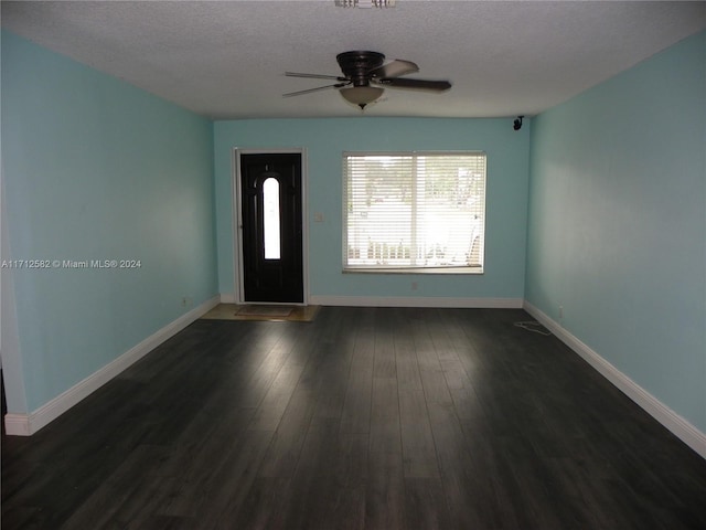 foyer with ceiling fan, dark wood-type flooring, and a textured ceiling