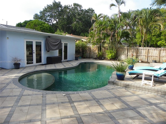 view of pool with french doors and a patio