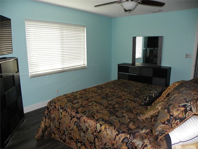 bedroom with dark hardwood / wood-style flooring and ceiling fan