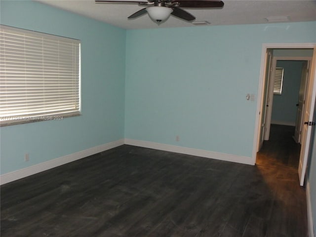 spare room with ceiling fan and dark hardwood / wood-style flooring