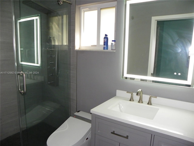 bathroom featuring vanity, toilet, and walk in shower