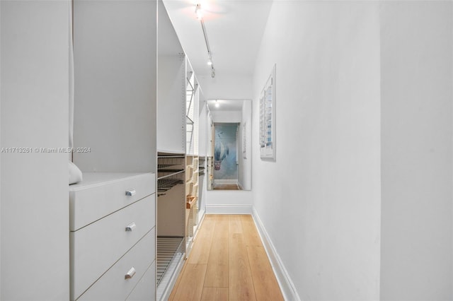 hallway featuring rail lighting and light hardwood / wood-style floors