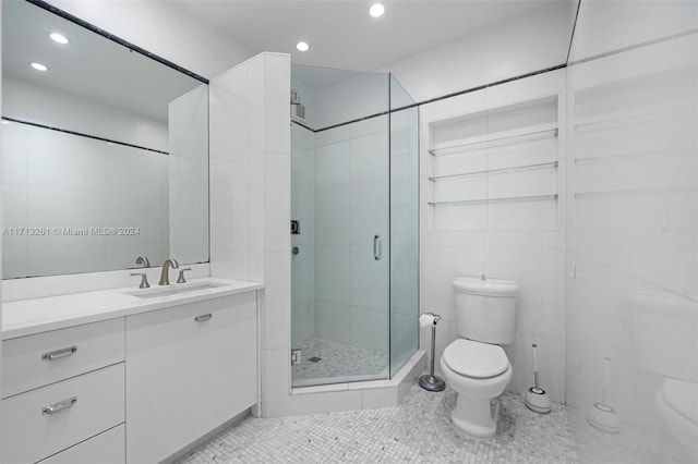 bathroom featuring vanity, tile patterned flooring, toilet, tile walls, and an enclosed shower