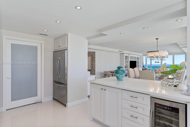 kitchen featuring stainless steel fridge, beverage cooler, decorative light fixtures, a notable chandelier, and white cabinets