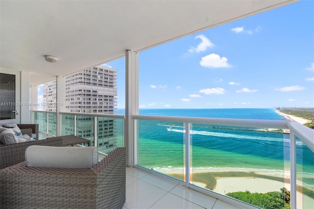 balcony with a water view and a view of the beach