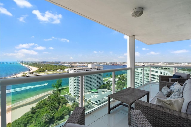 balcony featuring a beach view and a water view