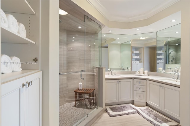 bathroom featuring hardwood / wood-style floors, vanity, a shower with door, and ornamental molding