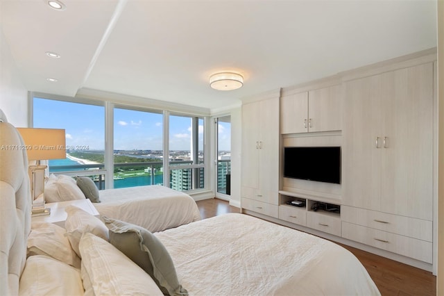 bedroom with access to outside, floor to ceiling windows, and dark hardwood / wood-style floors