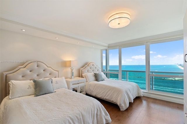 bedroom with wood-type flooring and a water view