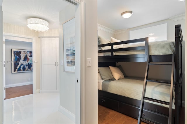 bedroom featuring a chandelier, wood-type flooring, and ornamental molding