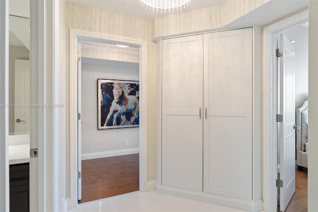 hall featuring a chandelier and light hardwood / wood-style floors