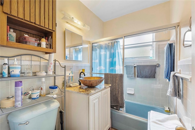 full bathroom with tile walls, toilet, backsplash, shower / bath combo with shower curtain, and vanity