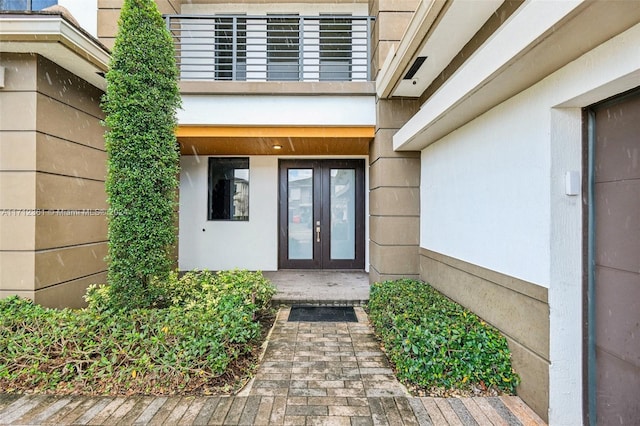 entrance to property featuring a balcony and french doors