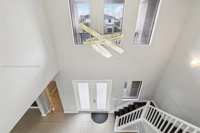 staircase featuring tile patterned flooring and a high ceiling