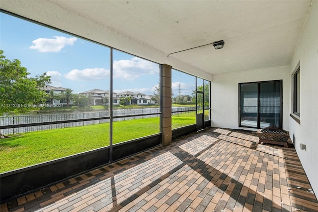 unfurnished sunroom featuring a water view