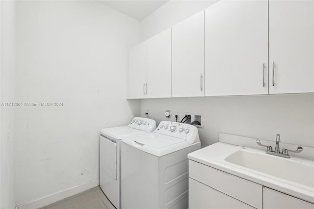 laundry area featuring sink, light tile patterned floors, cabinets, and independent washer and dryer