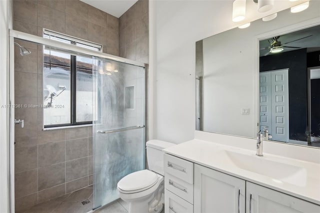 bathroom featuring vanity, toilet, walk in shower, and ceiling fan